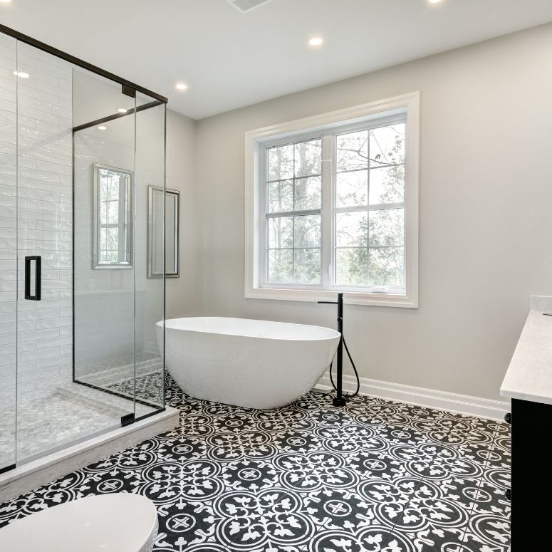 modern white and black bathroom with standalone tub and patterned tile flooring
