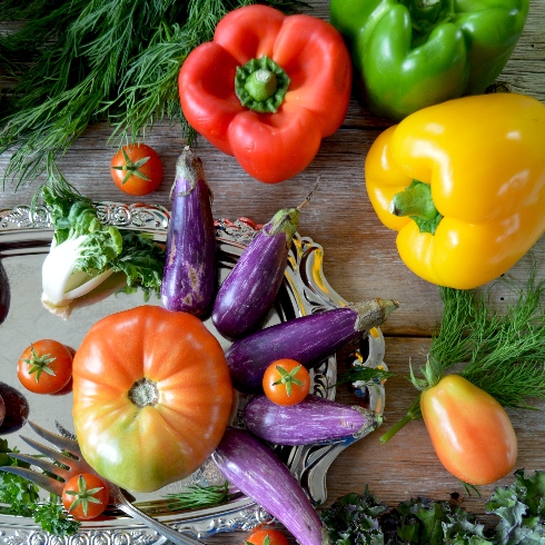 An assortment of bell peppers, eggplants, tomatoes and other vegetables