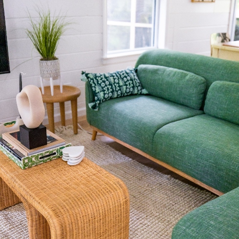 A green living room sofa and wooden coffee table