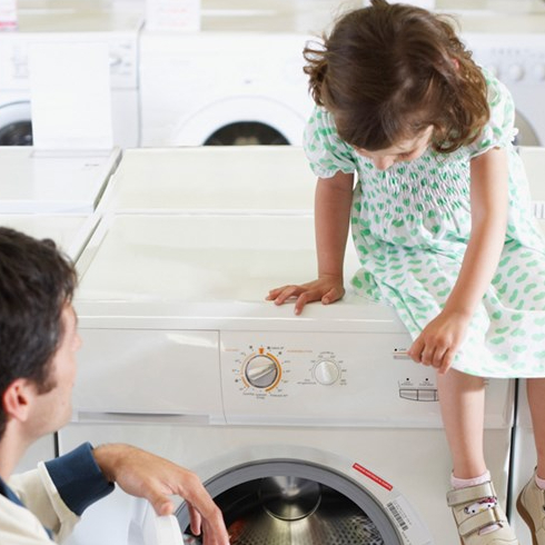 Father and daughter look at appliances