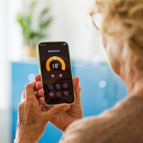 Woman adjusting thermostat from her phone.