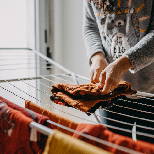 Midsection Of Woman Holding Clothes On Clothesline At Home - stock photo