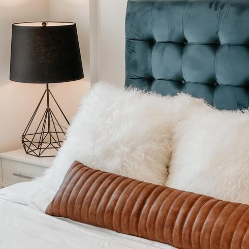 a white bedsheet with blue sideboards and a black lampshade