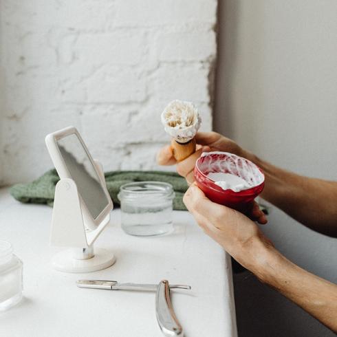 a person stirring shaving cream