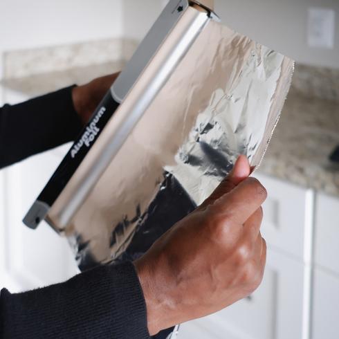 a person pulling tin foil out of a box