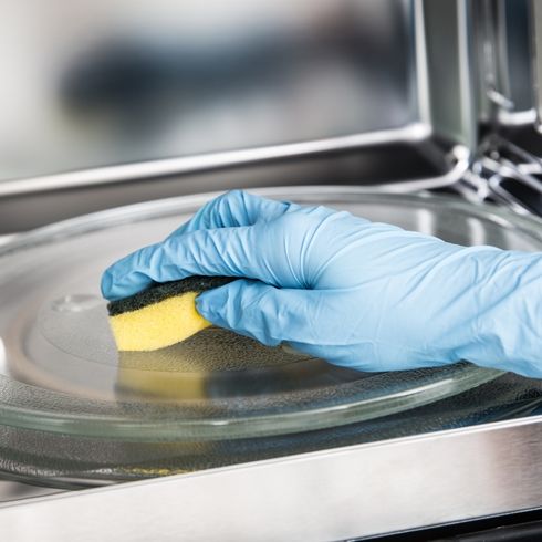 scrubbing microwave with sponge