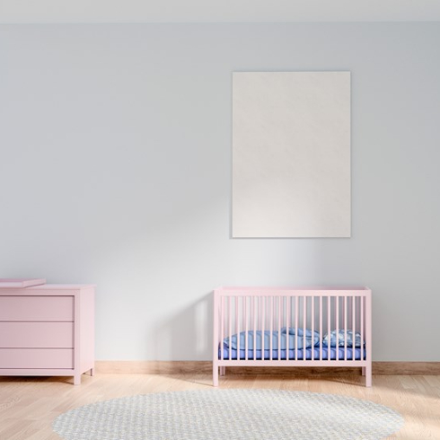 A plain painted artwork is hung above a baby's crib