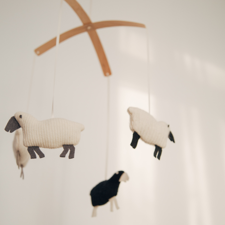 A baby mobile with little stuffed sheep