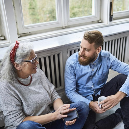 Woman and son sitting on floor in front of window