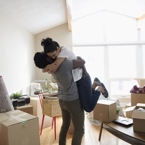 couple embrace amidst moving boxes