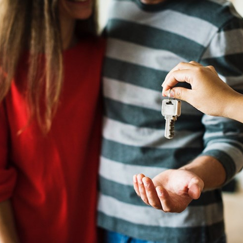 woman in red shirt and man in striped shirt get keys