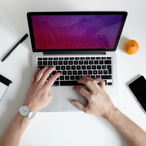 Laptop and papers on white desk