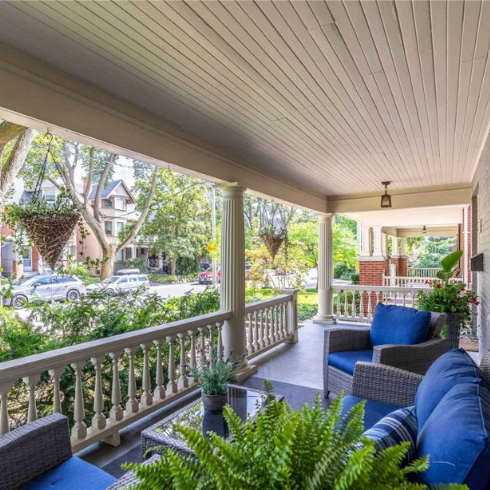 A tidy, uncluttered porch with blue patio seating and hanging plants.