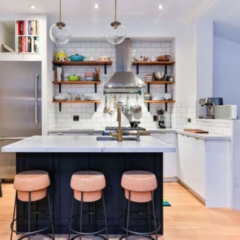 small kitchen with book storage above fridge and open shelves