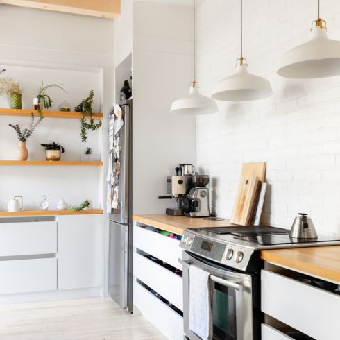 White kitchen with wood countertops and wood floating shelves