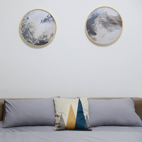 blue bed with headboard in light blue bedroom with round art on the walls