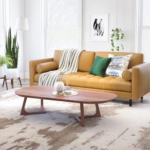 clean white living room with bright yellow couch and wood coffee table