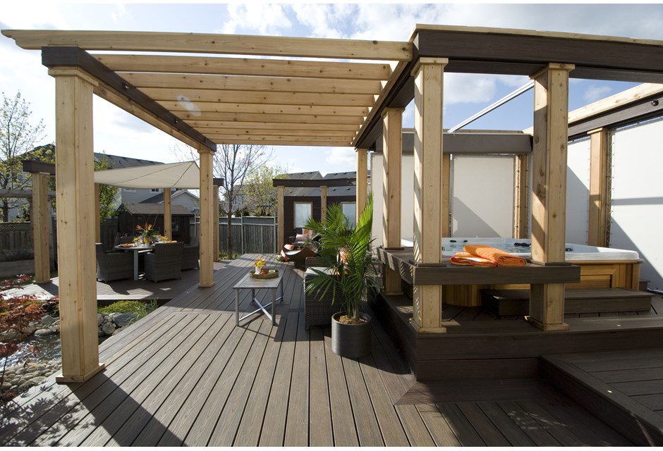 A linear wood pergola over a hot tub on a backyard deck