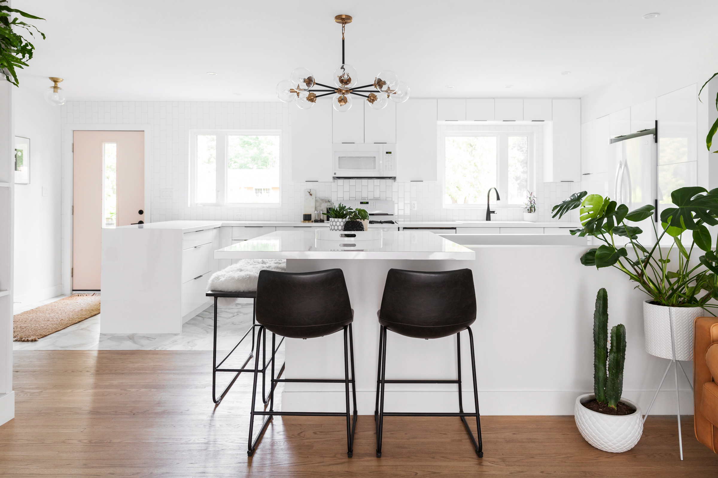 Break Up the Monotony Modern white kitchen with black and brass accents