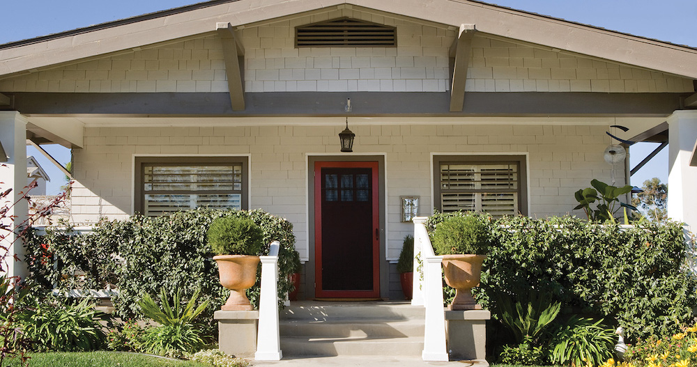 Small classic craftsman house with landscaped front yard, trim painted in BEHR Native Soil PPU7-24 and Top Tomato P180-7, and main siding shakes painted in BEHR White 52