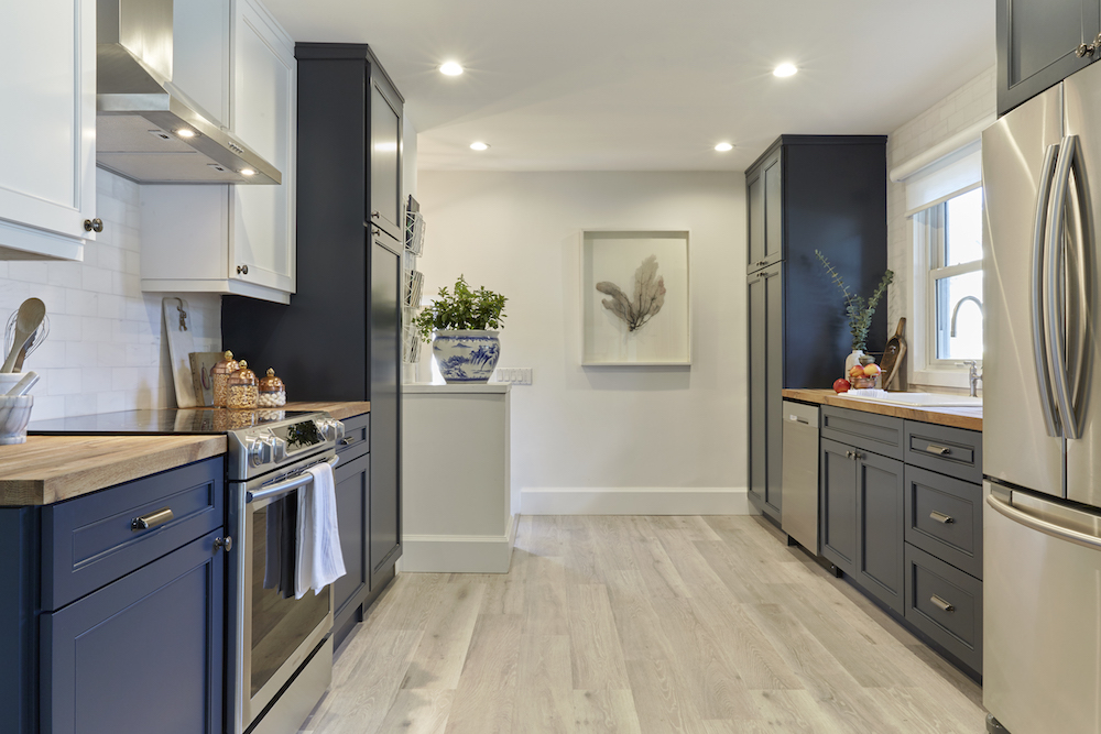 Timeless kitchen with blue cabinetry, light wood floors and wood countertops.