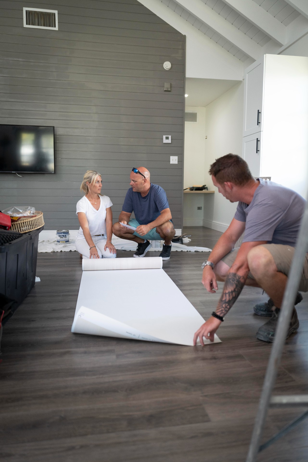 Sarah and Bryan Baeumler rolling out wallpaper in family villa