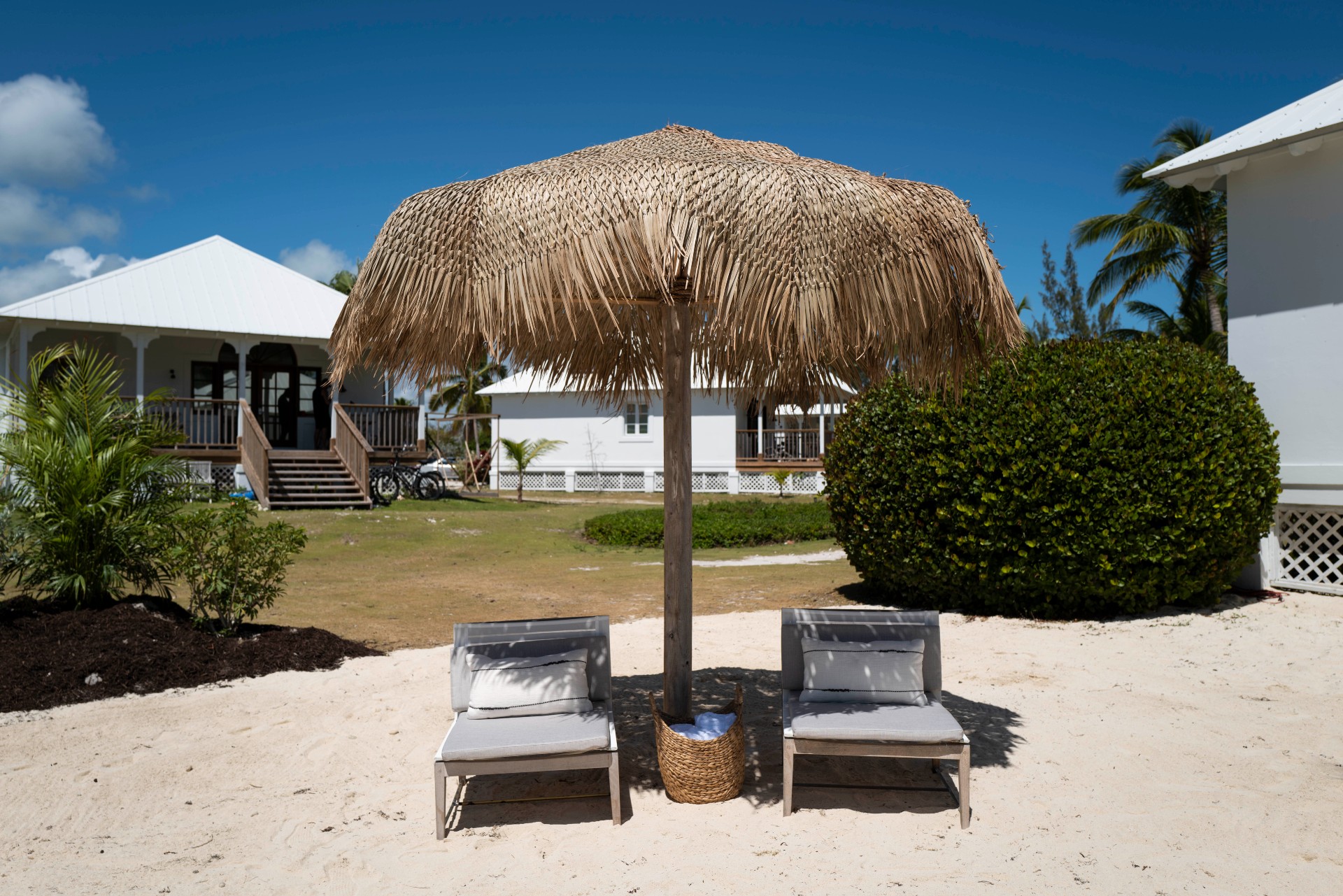 Island umbrella over two lounge chairs at the sport court