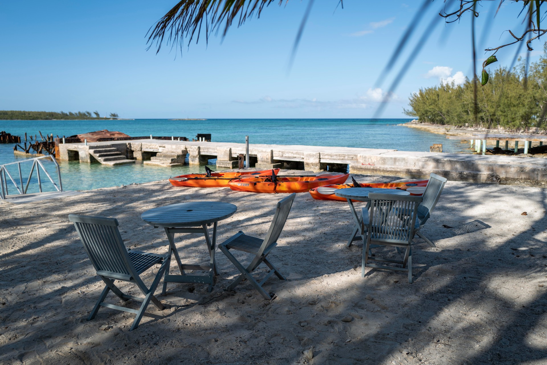 The waterfront seating area with wooden tables and chairs beside dock