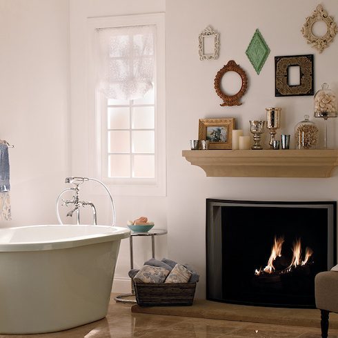 Classic luxury bathroom with a deep standalone soaker tub, floating stone vanity, ornate wall mirror, and wall painted in BEHR Cameo Stone N160-1