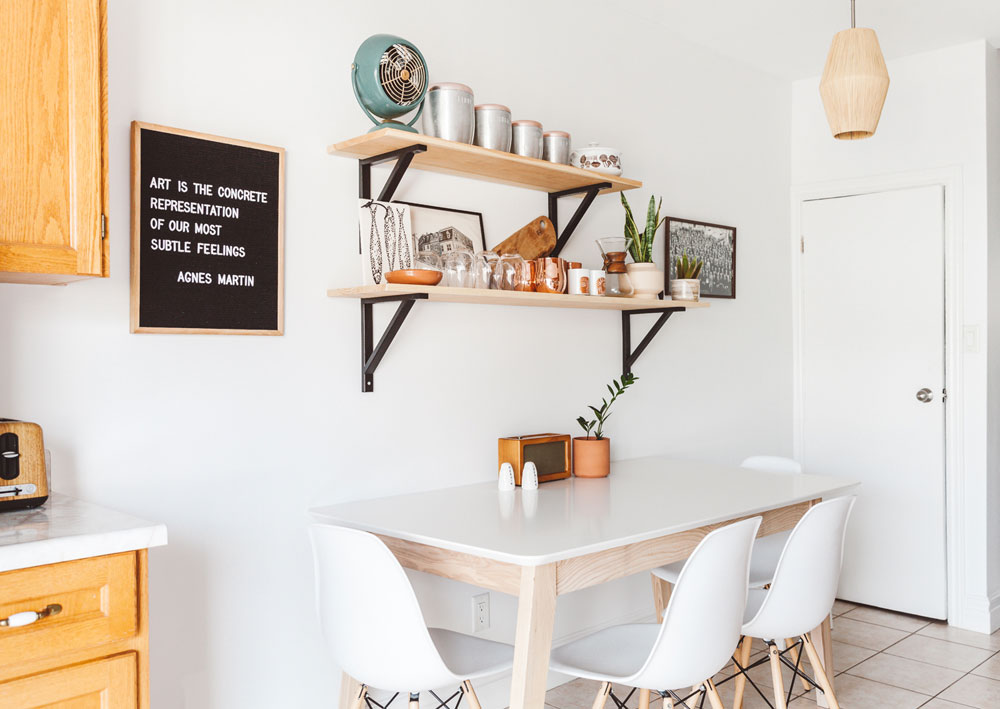 Small kitchen with compact table and stylish open shelving.