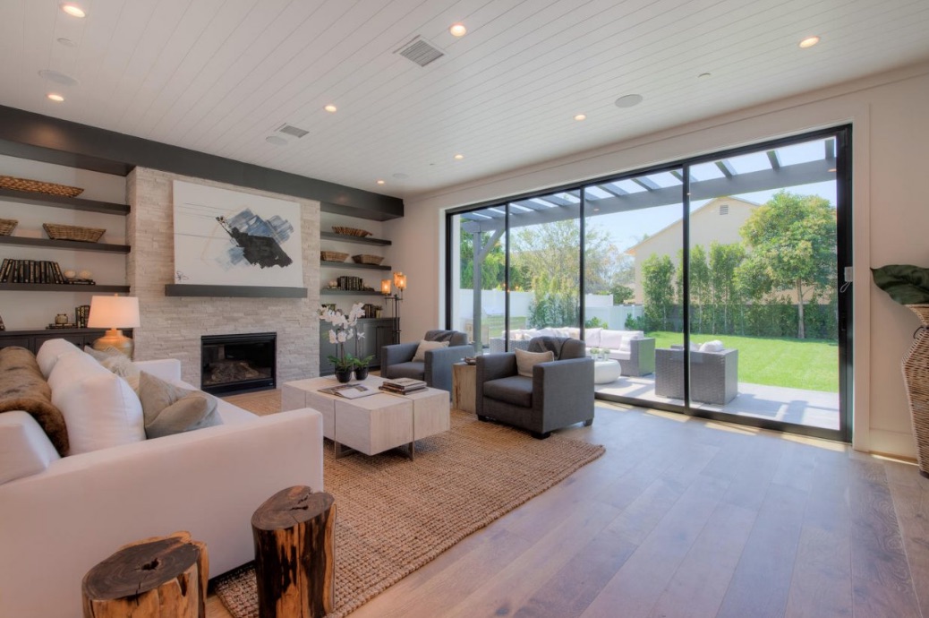 A family room with a floor-to-ceiling stacked-stone gas fireplace