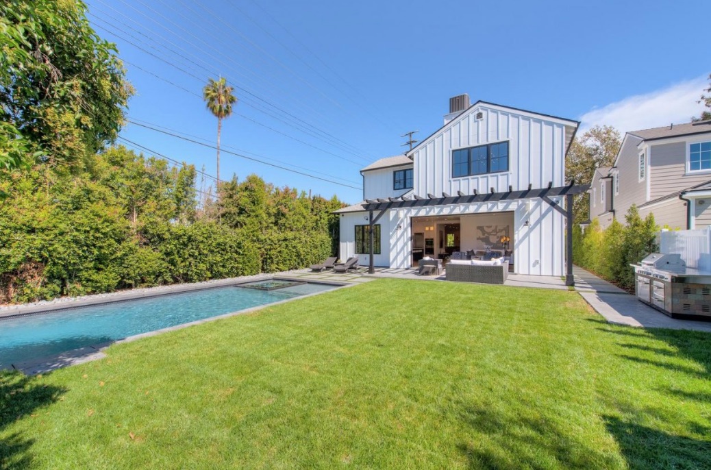 A spacious backyard with swimming pool and lush greenery