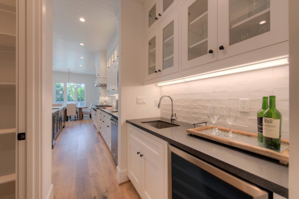 A pantry off to the side of the dining room with a narrow sink and countertop