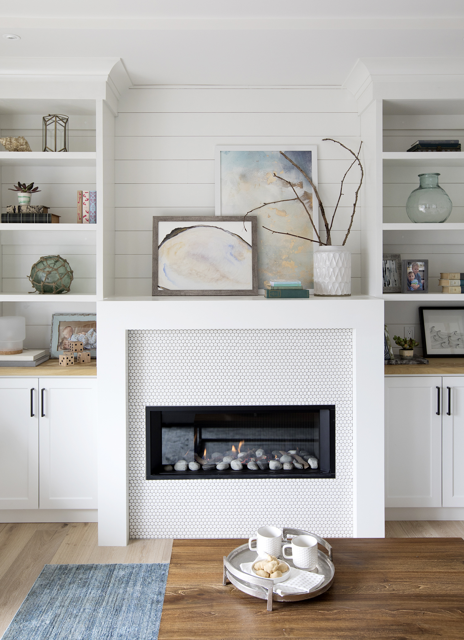 shiplap treatment in the living room is the backdrop to a plethora of penny tiles on the fireplace.