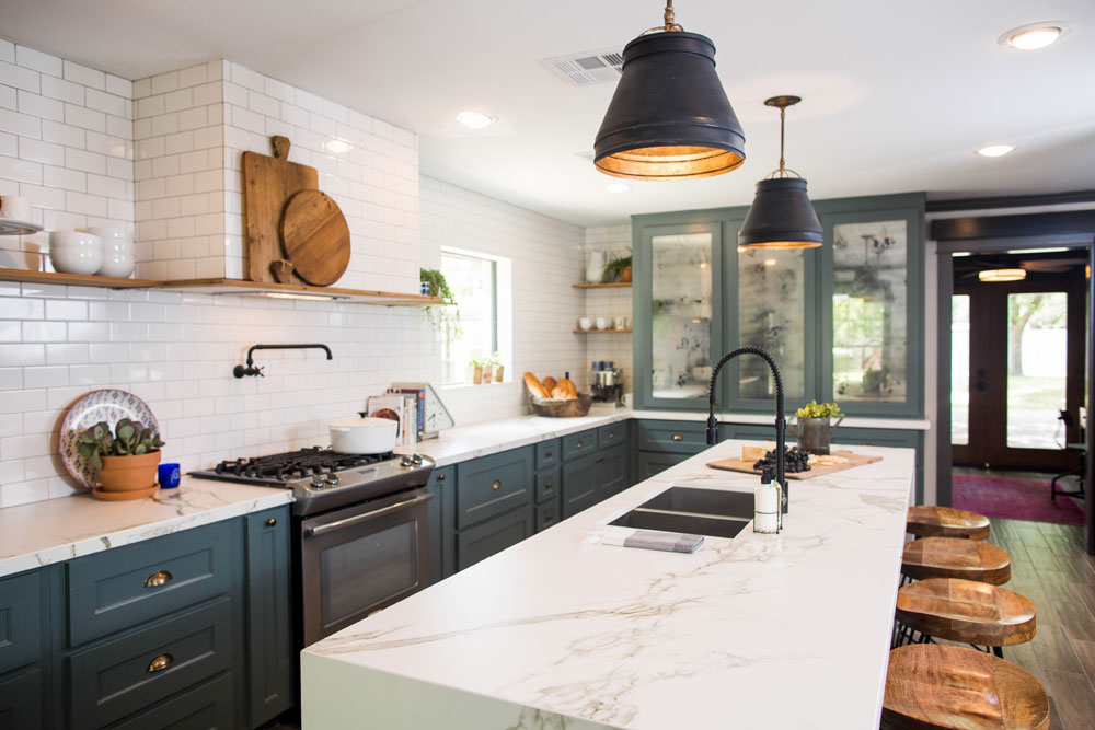 Modern rustic kitchen with blue cabinetry, marble countertops and hits of wood.