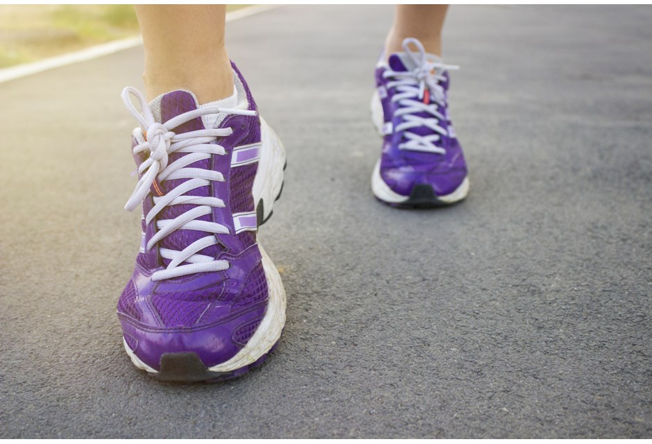 person running in running shoes on pavement