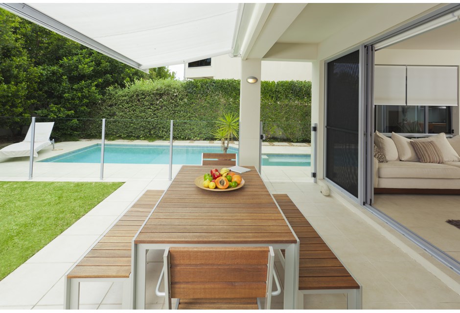 Sleek patio furniture overlook outdoor pool area