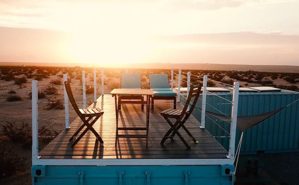 Deck on top of blue chipping container home