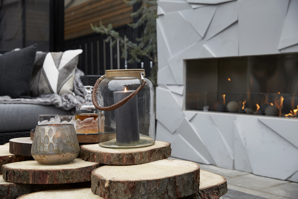 An outdoor fireplace surrounded by rustic furniture and lanterns