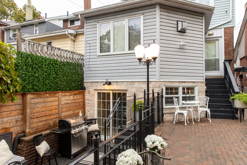 backyard with black wrought-iron fence and BBQ