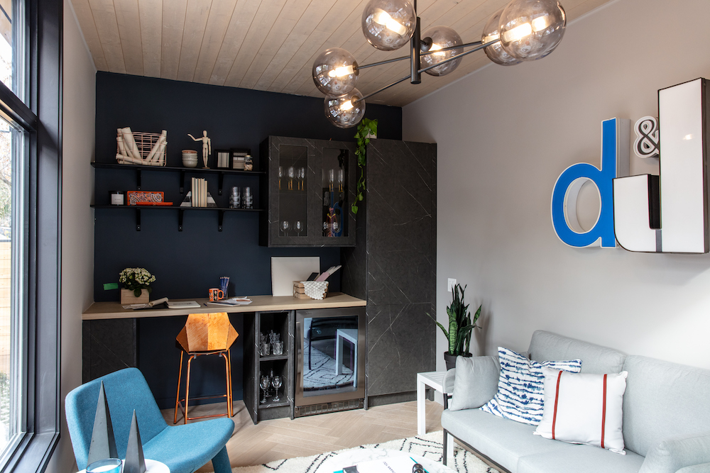 interior of backyard studio with marble-look cabinets and blue accent wall