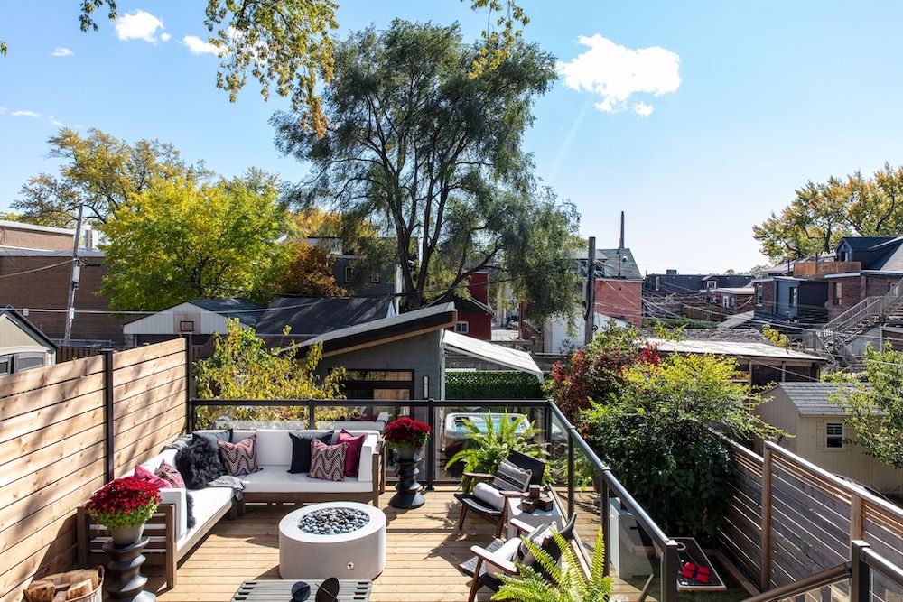 view of backyard with wooden deck, glass railings and gym structure in background