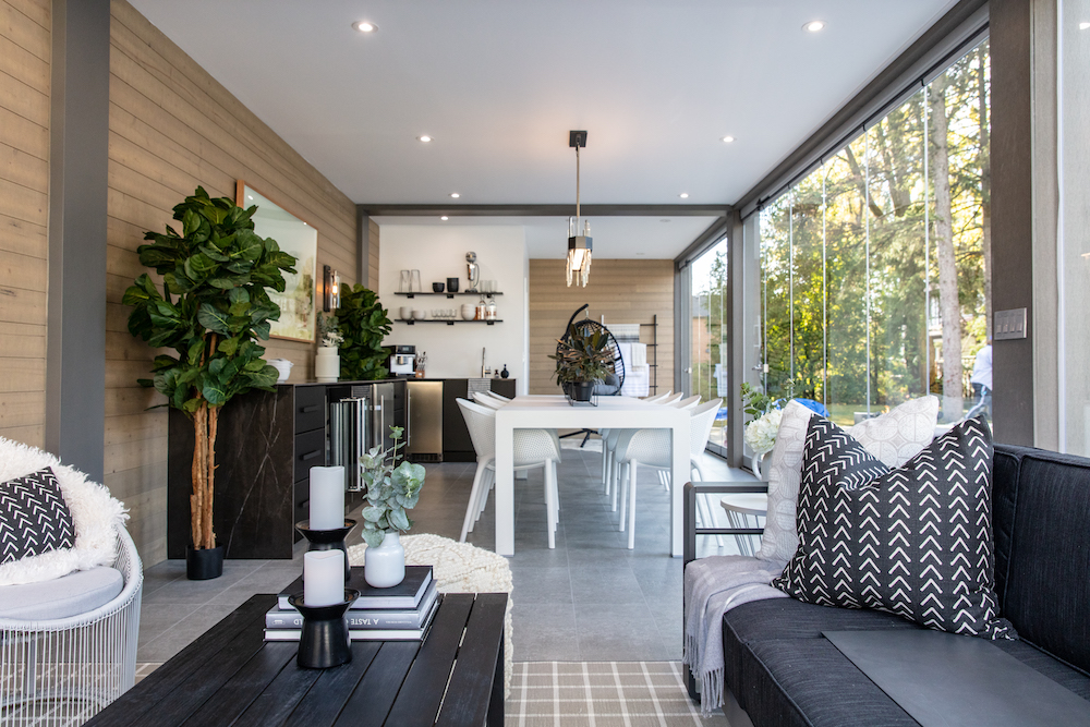 luxe open-concept lanai with couch in living space and white dining table in background