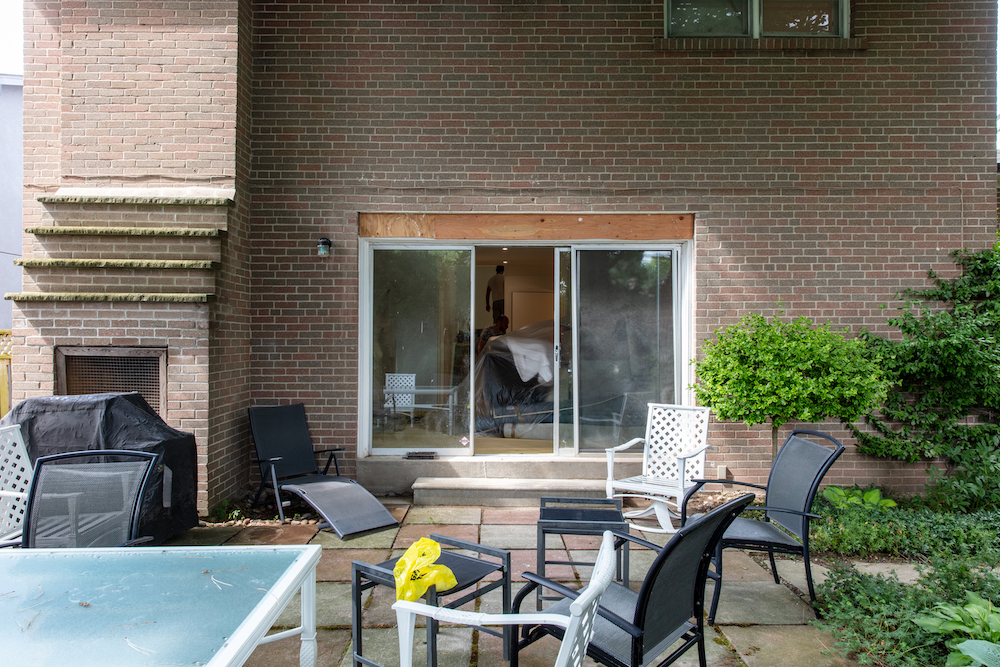 before, the backyard with a few black chairs and a wood-burning fireplace