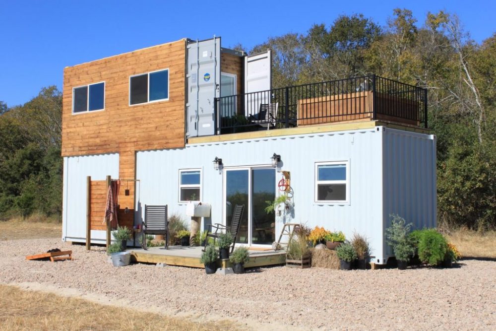 White custom container home with second smaller container on top for a second level