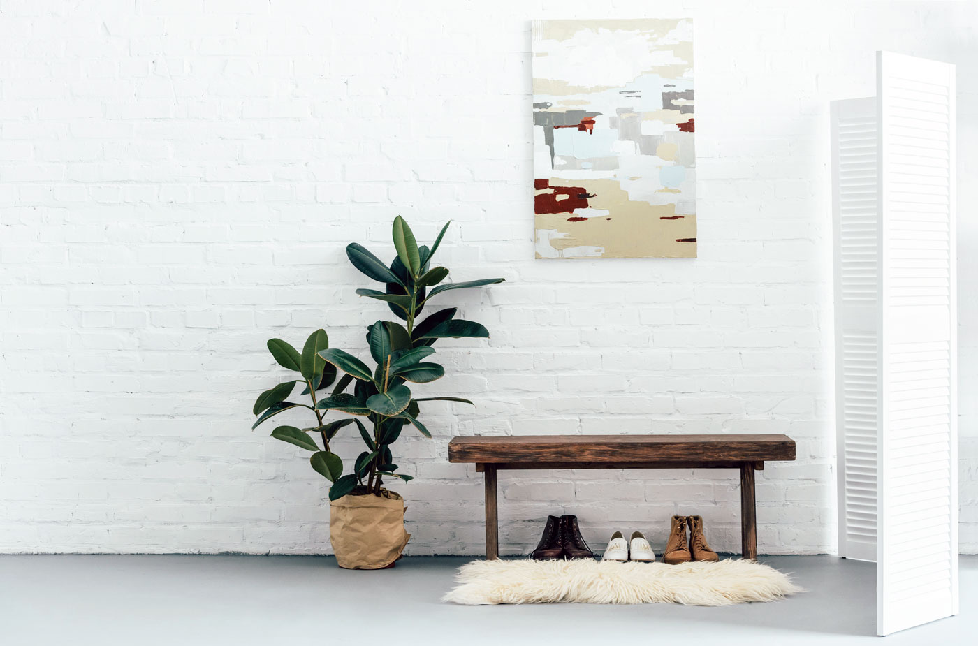 Modern basement with white room divider next to bench with shoes