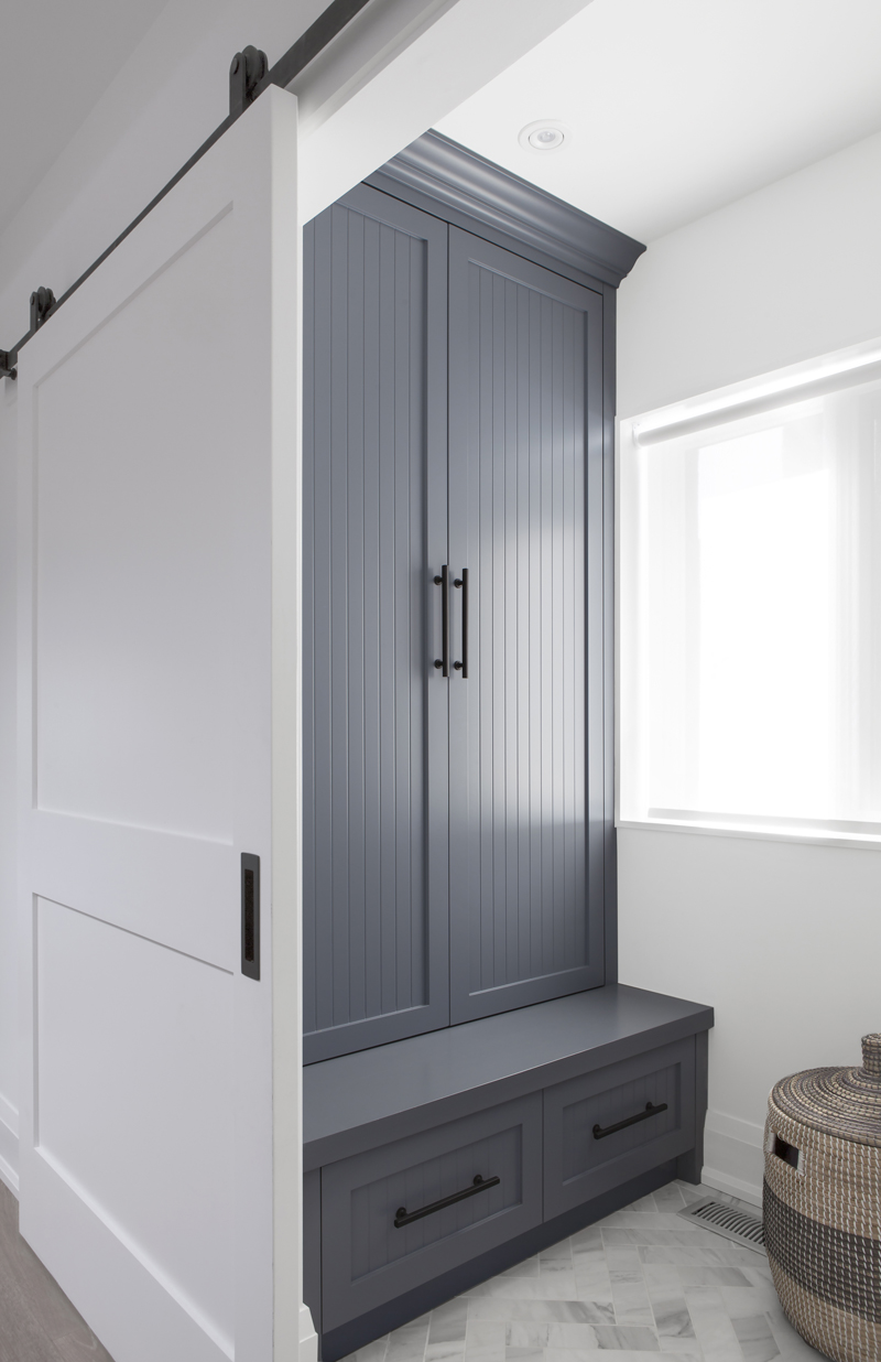 A mudroom with herringbone-style floor tile