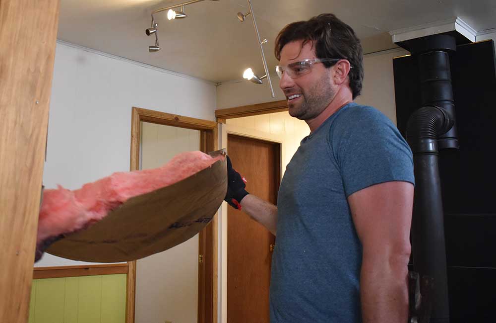 Scott McGillivray tearing out insulation at a vacation rental property