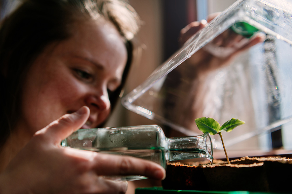 Woman with tiny greenhouse