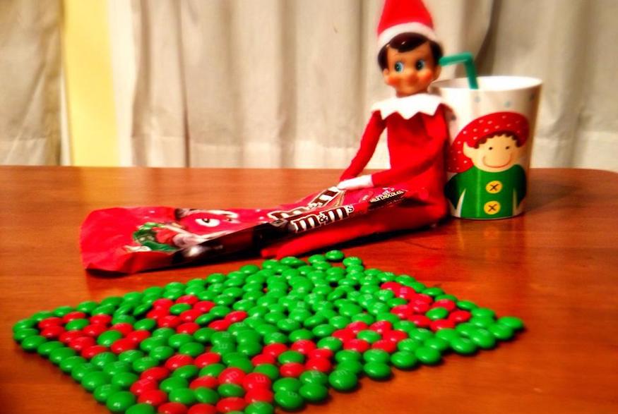 Elf on the shelf arranging m&ms